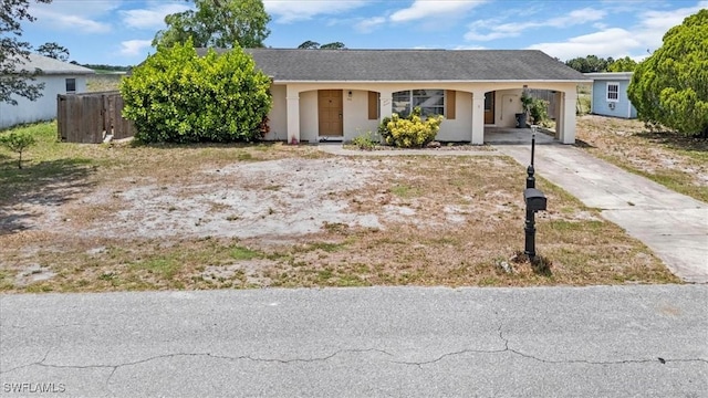 416 Rushmore Ave S, Lehigh Acres, FL 33936 - ranch-style house with concrete driveway, a carport, and stucco siding