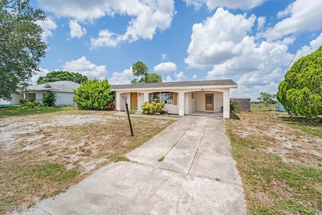 416 Rushmore Ave S, Lehigh Acres, FL 33936 - ranch-style home with driveway, an attached carport, and stucco siding