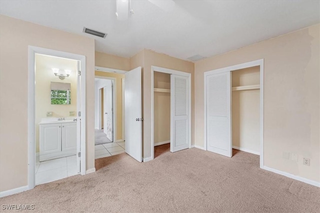 416 Rushmore Ave S, Lehigh Acres, FL 33936 - unfurnished bedroom featuring carpet, baseboards, two closets, and ensuite bathroom