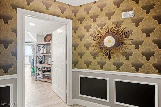 2745 1st St Unit 1602, Fort Myers, FL 33916 - hallway featuring wallpapered walls, wainscoting, and wood finished floors
