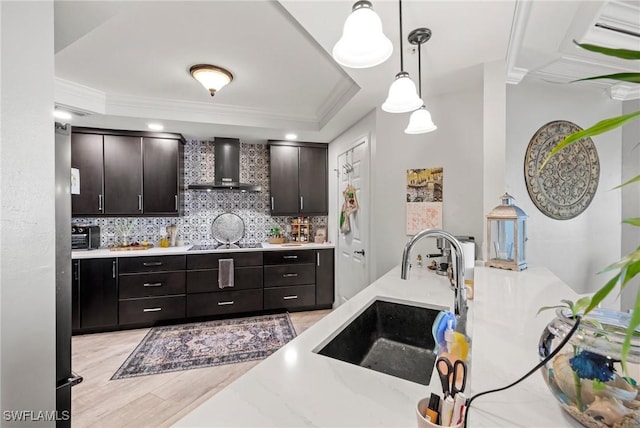 2745 1st St Unit 1602, Fort Myers, FL 33916 - kitchen featuring wall chimney range hood, a sink, black electric stovetop, tasteful backsplash, and light wood-type flooring