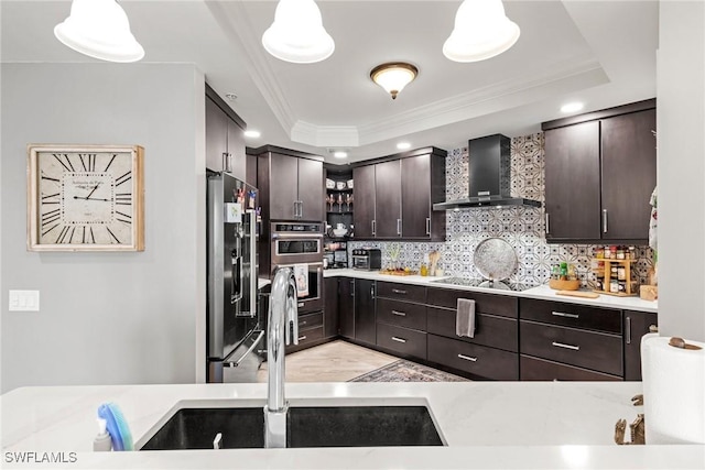 2745 1st St Unit 1602, Fort Myers, FL 33916 - kitchen featuring wall chimney range hood, stainless steel appliances, a tray ceiling, ornamental molding, and tasteful backsplash