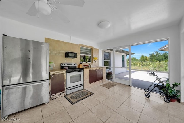 3304 44th St SW, Lehigh Acres, FL 33976 - kitchen featuring stainless steel appliances, a sink, light tile patterned floors, and a ceiling fan