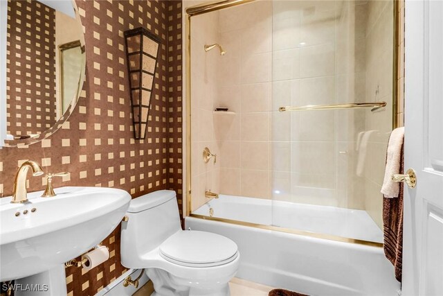 900 5th Ave S Unit 302, Naples, FL 34102 - full bath with toilet, bath / shower combo with glass door, wallpapered walls, and a sink
