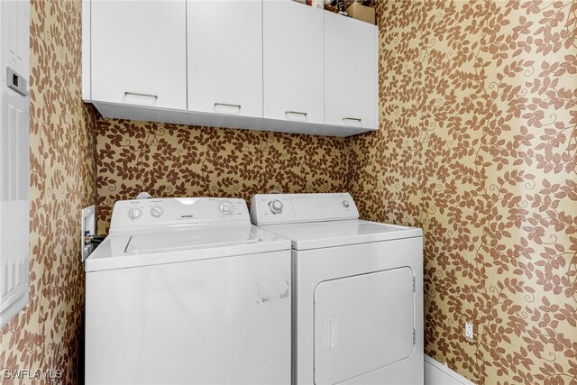 900 5th Ave S Unit 302, Naples, FL 34102 - laundry area with wallpapered walls, cabinet space, and washing machine and dryer