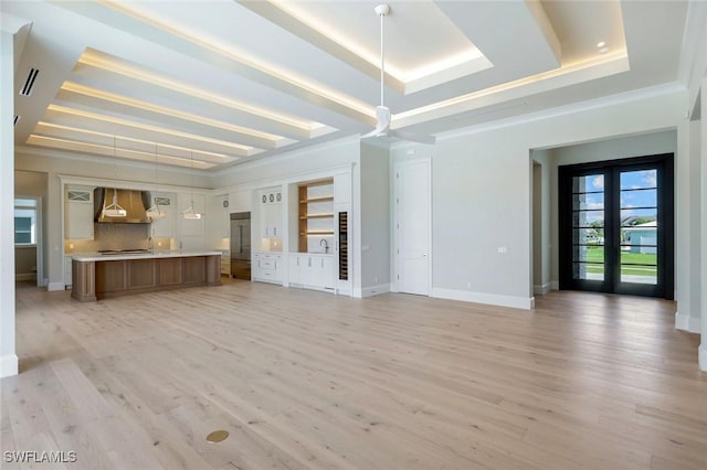 954 Sundrop Ct, Marco Island, FL 34145 - unfurnished living room featuring a tray ceiling, light wood finished floors, ornamental molding, and baseboards