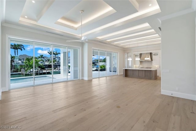 954 Sundrop Ct, Marco Island, FL 34145 - unfurnished living room featuring a raised ceiling, light wood-style flooring, and baseboards