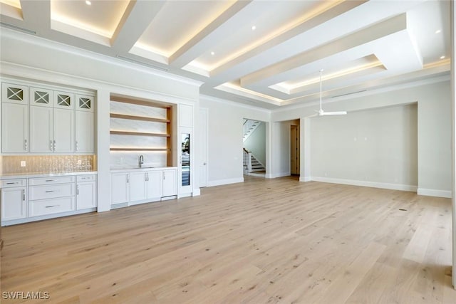 954 Sundrop Ct, Marco Island, FL 34145 - unfurnished living room featuring stairs, bar with sink, a raised ceiling, light wood-style flooring, and ornamental molding