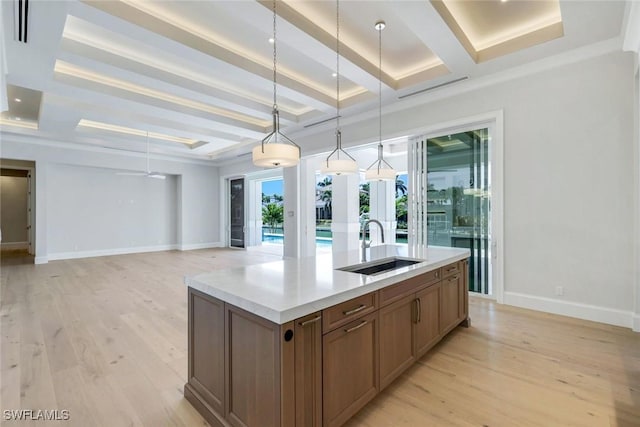 954 Sundrop Ct, Marco Island, FL 34145 - kitchen featuring a sink, baseboards, a kitchen island with sink, light wood-type flooring, and pendant lighting