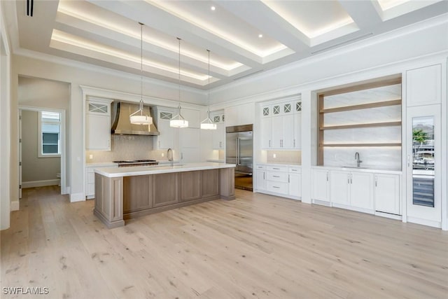 954 Sundrop Ct, Marco Island, FL 34145 - kitchen featuring wall chimney exhaust hood, built in fridge, backsplash, light countertops, and white cabinetry