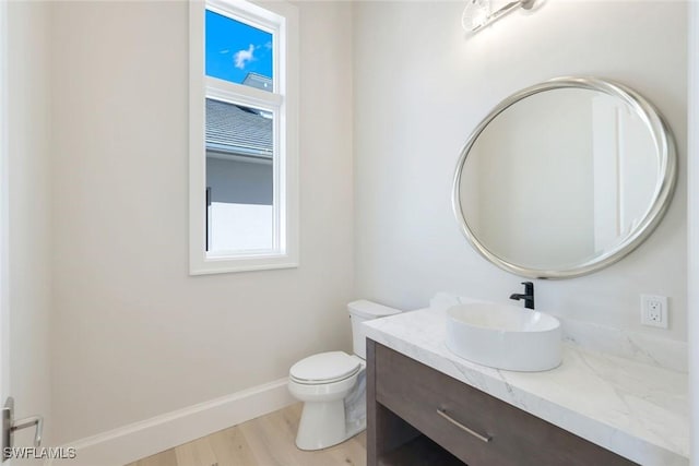 954 Sundrop Ct, Marco Island, FL 34145 - half bath with vanity, wood finished floors, toilet, and baseboards