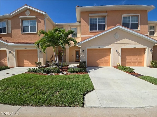 8874 Via Isola Ct, Fort Myers, FL 33966 - townhome / multi-family property with stucco siding, concrete driveway, and a front lawn
