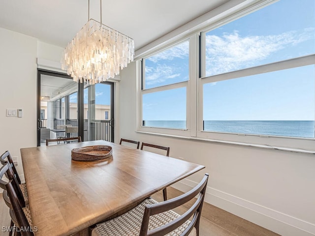 9375 Gulf Shore Dr Unit 601, Naples, FL 34108 - dining space with a chandelier, baseboards, and wood finished floors