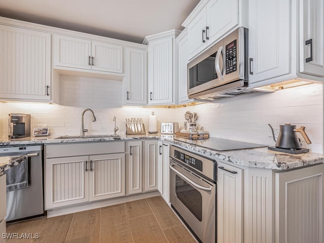9375 Gulf Shore Dr Unit 601, Naples, FL 34108 - kitchen featuring stainless steel appliances, a sink, decorative backsplash, and light stone countertops