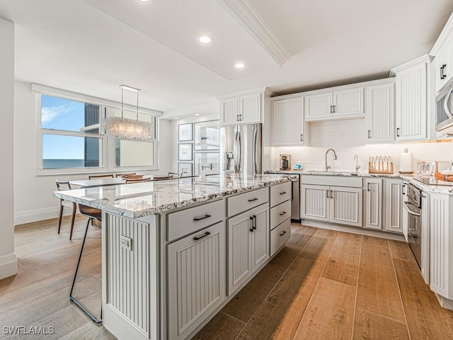 9375 Gulf Shore Dr Unit 601, Naples, FL 34108 - kitchen with stainless steel appliances, a kitchen island, light wood-style flooring, a chandelier, and recessed lighting