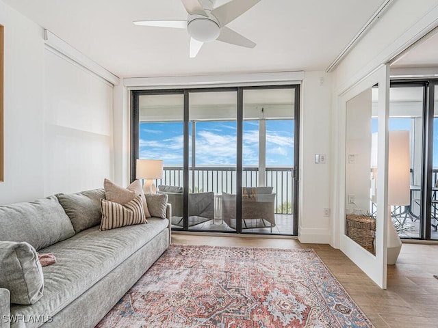 9375 Gulf Shore Dr Unit 601, Naples, FL 34108 - living area with a ceiling fan, healthy amount of natural light, wood finished floors, and expansive windows