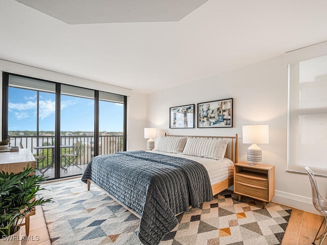 9375 Gulf Shore Dr Unit 601, Naples, FL 34108 - bedroom with access to exterior, a water view, baseboards, and light wood-type flooring