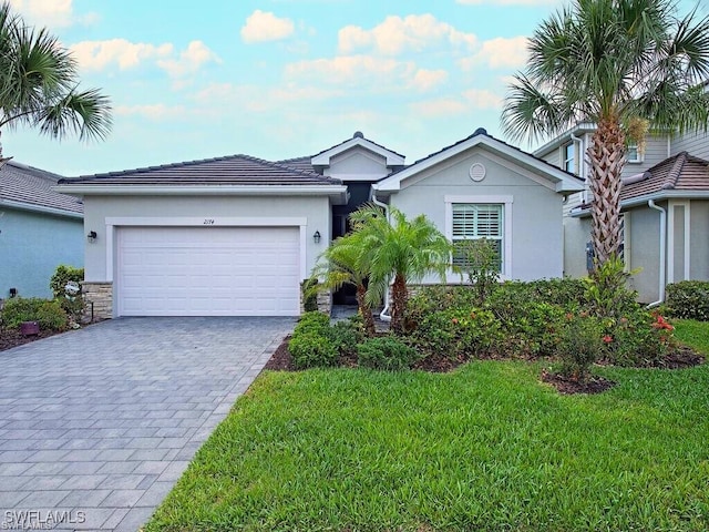 2174 Clementine St, Naples, FL 34120 - ranch-style home with decorative driveway, a garage, a front yard, and stucco siding