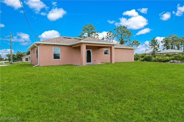 3113 68th St W, Lehigh Acres, FL 33971 - rear view of house with stucco siding, a lawn, and a shingled roof