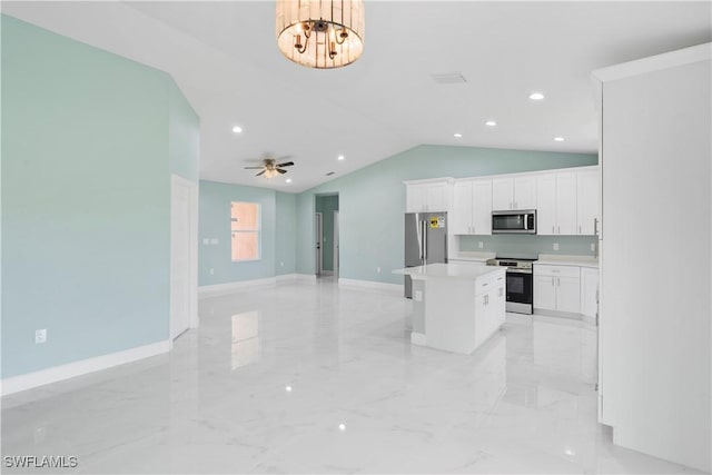 3113 68th St W, Lehigh Acres, FL 33971 - kitchen with appliances with stainless steel finishes, a center island, light marble finish floors, lofted ceiling, and white cabinets