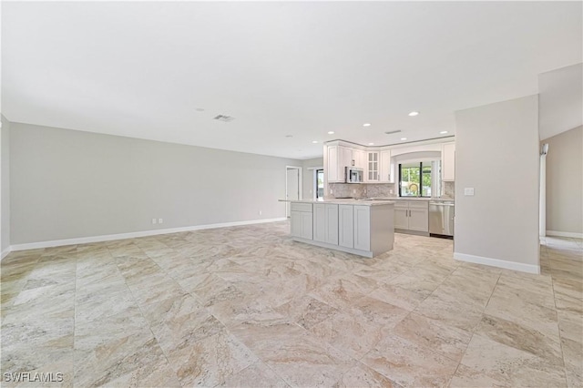 14938 Randolph Dr, Fort Myers, FL 33905 - kitchen with stainless steel appliances, light countertops, open floor plan, glass insert cabinets, and baseboards