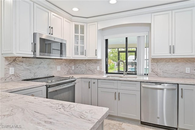 14938 Randolph Dr, Fort Myers, FL 33905 - kitchen with stainless steel appliances, a sink, light stone counters, glass insert cabinets, and backsplash