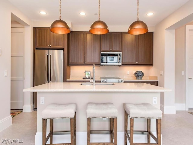 1030 3rd Ave S Unit 406, Naples, FL 34102 - kitchen with appliances with stainless steel finishes, a sink, light countertops, a breakfast bar area, and pendant lighting