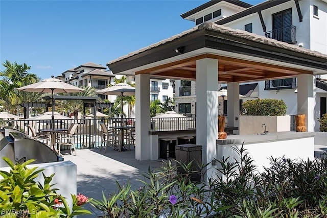 1030 3rd Ave S Unit 406, Naples, FL 34102 - back of property featuring a gazebo, stucco siding, and a sink