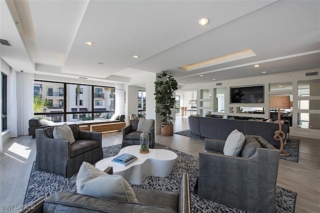 1030 3rd Ave S Unit 406, Naples, FL 34102 - living room featuring a raised ceiling and wood finished floors