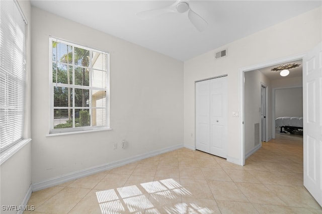 1630 Tarpon Bay Dr S Unit 102, Naples, FL 34119 - unfurnished bedroom with light tile patterned flooring, multiple windows, a closet, and baseboards
