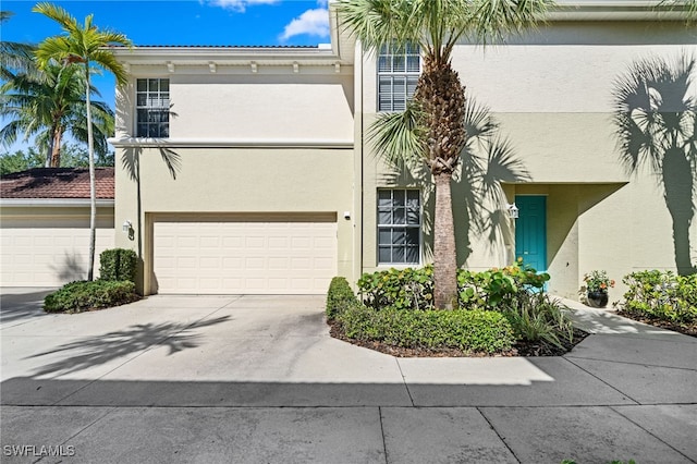 1630 Tarpon Bay Dr S Unit 102, Naples, FL 34119 - view of front of house with stucco siding, driveway, and an attached garage