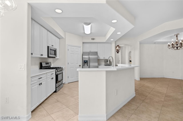 1630 Tarpon Bay Dr S Unit 102, Naples, FL 34119 - kitchen with appliances with stainless steel finishes, a tray ceiling, arched walkways, light tile patterned floors, and recessed lighting