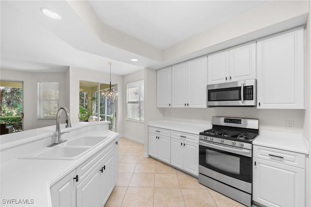 1630 Tarpon Bay Dr S Unit 102, Naples, FL 34119 - kitchen featuring appliances with stainless steel finishes, a sink, white cabinets, light countertops, and light tile patterned floors