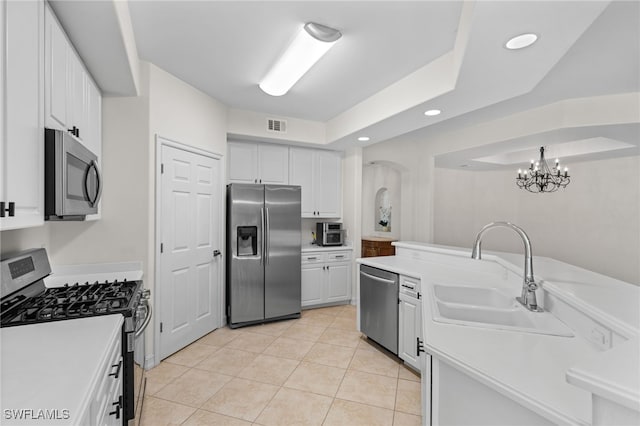 1630 Tarpon Bay Dr S Unit 102, Naples, FL 34119 - kitchen with appliances with stainless steel finishes, a sink, white cabinets, light countertops, and light tile patterned flooring