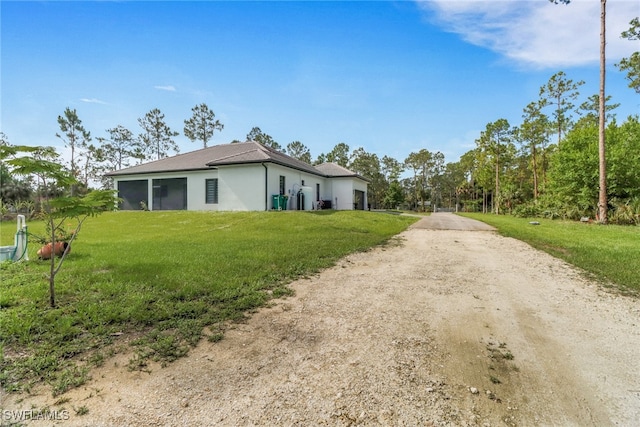 2909 2nd Ave NE, Naples, FL 34120 - view of side of property with driveway, stucco siding, and a yard
