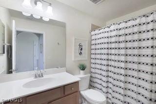 9834 Giaveno Cir Unit 1716, Naples, FL 34113 - bathroom with vanity, toilet, and a shower with shower curtain