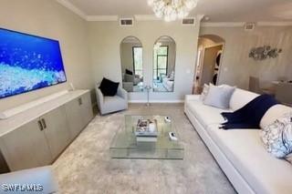 9834 Giaveno Cir Unit 1716, Naples, FL 34113 - living room featuring arched walkways, crown molding, and a chandelier