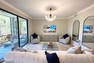 9834 Giaveno Cir Unit 1716, Naples, FL 34113 - living area with a chandelier and crown molding