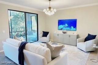 9834 Giaveno Cir Unit 1716, Naples, FL 34113 - living area with a chandelier, ornamental molding, and baseboards