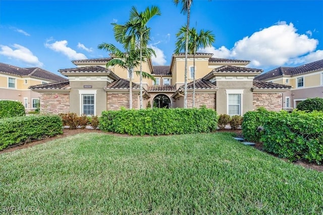 9528 Ironstone Ter Unit 201, Naples, FL 34120 - view of front of home featuring stone siding, stucco siding, a front yard, and a tile roof