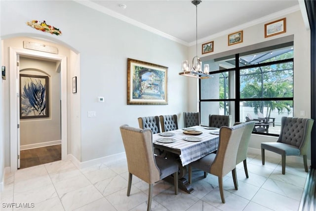 605 SW 39th Ave, Cape Coral, FL 33991 - dining area featuring crown molding, a chandelier, baseboards, and arched walkways