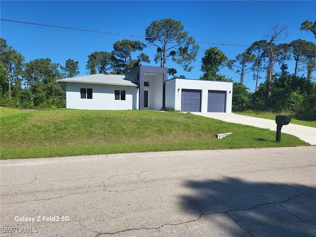 521 Frank Jewett Ave S, Lehigh Acres, FL 33974 - view of front of house with a front yard, stucco siding, an attached garage, and driveway