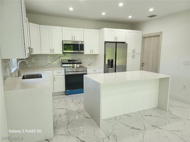 521 Frank Jewett Ave S, Lehigh Acres, FL 33974 - kitchen with stainless steel appliances, a sink, recessed lighting, backsplash, and white cabinetry