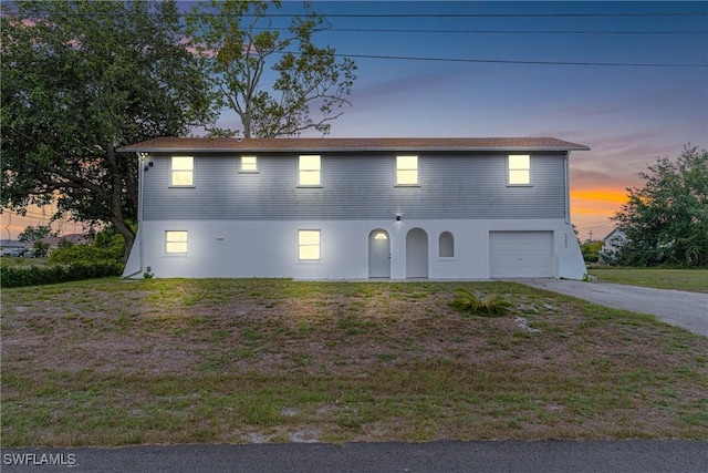 3303 6th St SW, Lehigh Acres, FL 33976 - view of front of property featuring driveway, an attached garage, a yard, and stucco siding