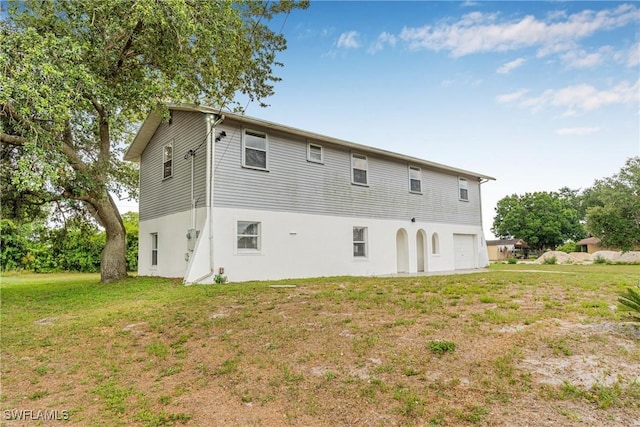 3303 6th St SW, Lehigh Acres, FL 33976 - rear view of property featuring stucco siding and a yard