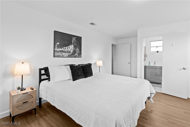 3303 6th St SW, Lehigh Acres, FL 33976 - bedroom featuring wood finished floors, baseboards, and ensuite bath