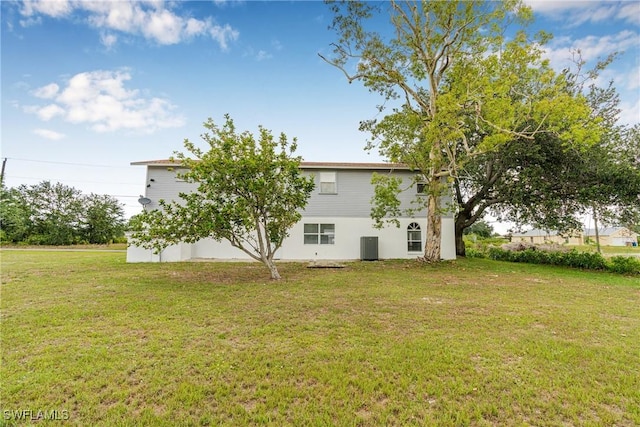 3303 6th St SW, Lehigh Acres, FL 33976 - view of side of property featuring a lawn and central air condition unit