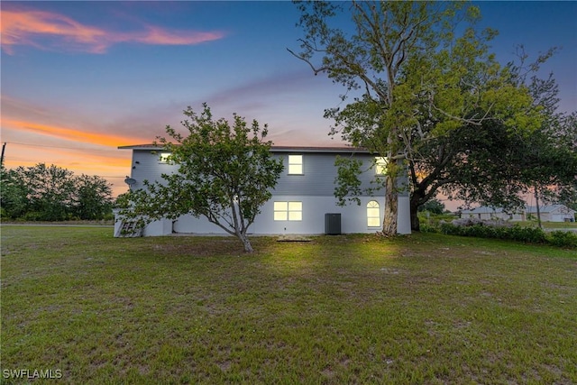 3303 6th St SW, Lehigh Acres, FL 33976 - property exterior at dusk featuring a lawn
