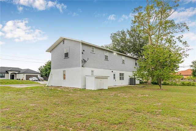 3303 6th St SW, Lehigh Acres, FL 33976 - rear view of property featuring central AC unit, a lawn, and stucco siding