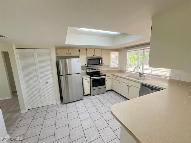 1706 Forest Lakes Blvd, Naples, FL 34105 - kitchen featuring stainless steel appliances, a sink, light countertops, a tray ceiling, and light tile patterned floors